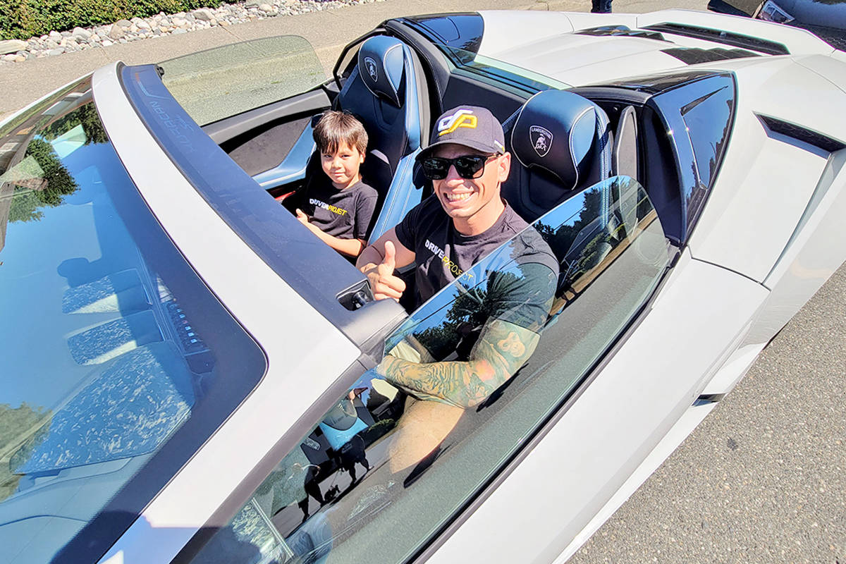 A volunteer driver gave a thumbs-up as a fleet of supercars paid Langley City teen Alyssa Anderson a visit on Sunday, July 25, as part of the Drive Project that aims to bring a little motorized magic to special kids. (Dan Ferguson/Langley Advance Times)