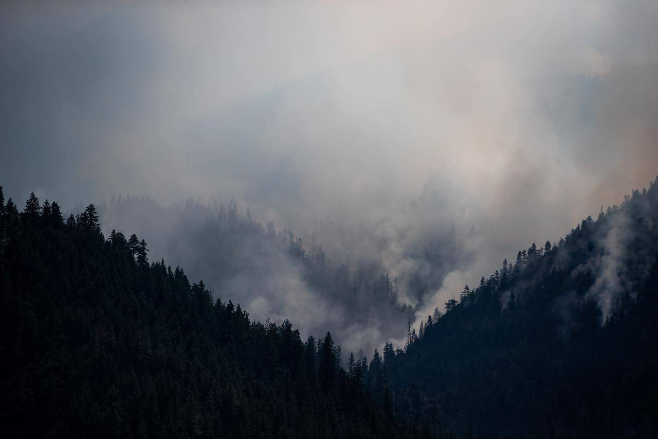 A wildfire burns on a mountain above the Trans-Canada Highway near Lytton, B.C., on Friday, July 9, 2021. British Columbia is reporting a slight increase in the number of active wildfires but cooler temperatures and forecasts of rain ahead could bring some relief. THE CANADIAN PRESS/Darryl Dyck