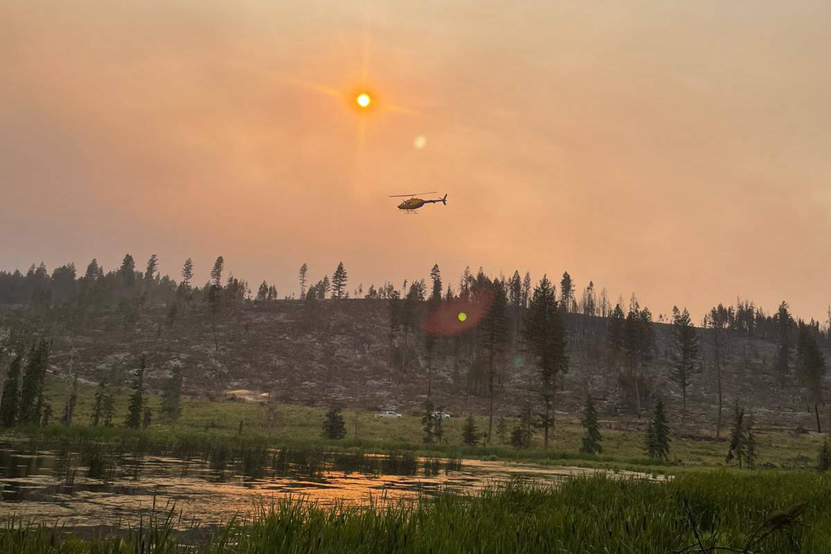 A helicopter delivers water onto the White Rock Lake wildfire burning near Westwold on July 24. (BC Wildfire Services)