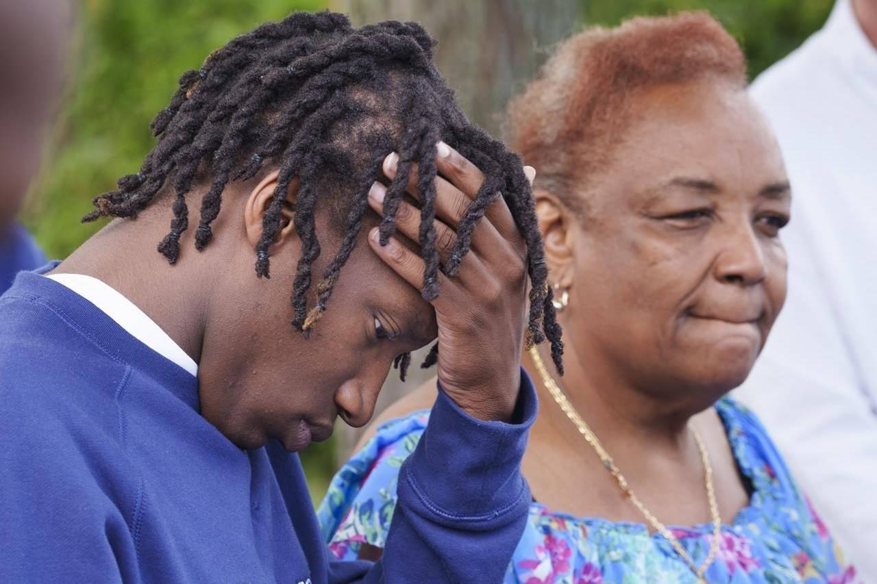 Kayshawn Olivier, son of Jean-René Junior Olivier who was shot dead by police officers, pauses next to the mother of the victim, Marie-Mireille Bence, during a news conference in Repentigny, Que., on Monday, Aug. 2, 2021. THE CANADIAN PRESS/Paul Chiasson