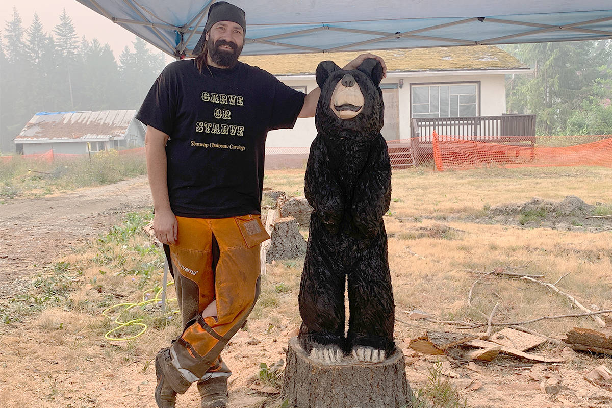 Chainsaw artist Mike Ormondy puts the finishing touches on his bear carving in Sicamous on Aug. 3, 2021. (Zachary Roman-Eagle Valley News)