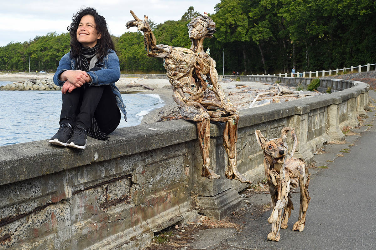 Artist Tanya Bub sits along the Dallas waterfront with her sculpture of a man called ' Arthur Heart' and one of a small dog. Don Denton photograph