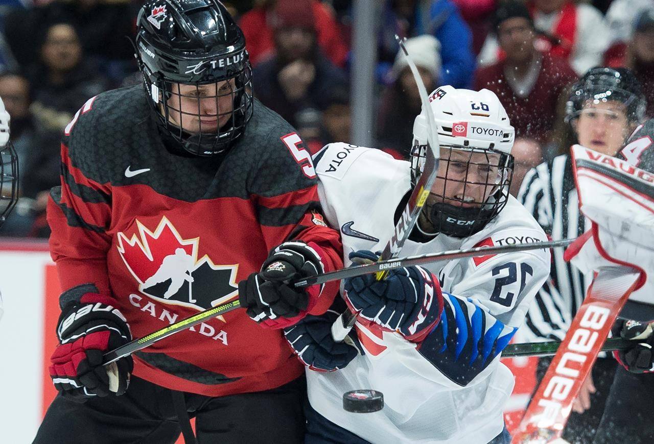 Team Canada's Rougeau Lauriane fights for control of the puck with U.S.A.'s Kendall Coyne Schofield during first period of Women's Rivalry Series hockey action in Vancouver on February 5, 2020. THE CANADIAN PRESS/Jonathan Hayward