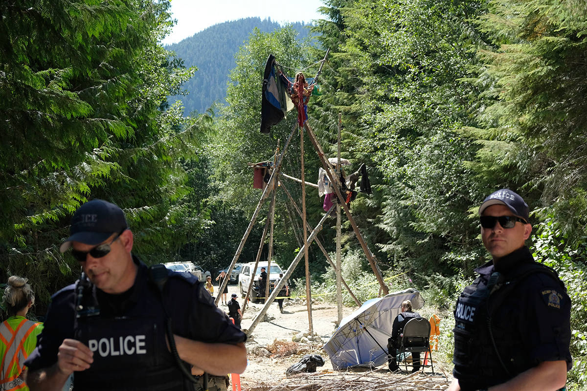 RCMP officers wait for protesters in tripods, sleeping dragons and coffins to voluntarily remove themselves earlier this summer in a remote part of southwest Vancouver Island. (Black Press Media file photo)