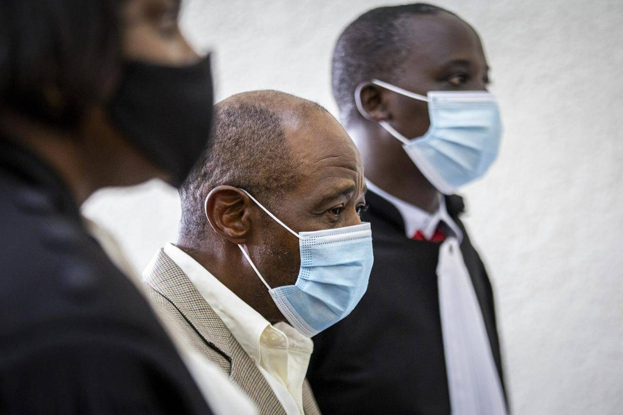 FILE - In this Monday, Sept. 14, 2020 file photo, Paul Rusesabagina, center, whose story inspired the film "Hotel Rwanda" for saving people from genocide, appears at the Kicukiro Primary Court in the capital Kigali, Rwanda. A court in Rwanda said Monday, Sept. 20, 2021 that Rusesabagina, who boycotted the announcement after declaring he didn't expect justice in a trial he called a "sham", is guilty of terror-related offenses. (AP Photo, File)