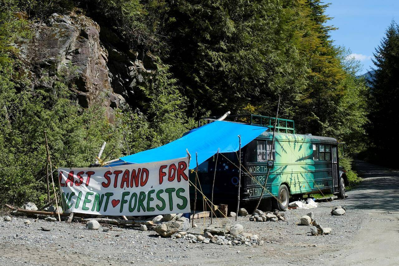 A bus and sign are shown near the Eden blockade in the Fairy Creek area near Port Renfrew, B.C., on May, 11, 2021. THE CANADIAN PRESS