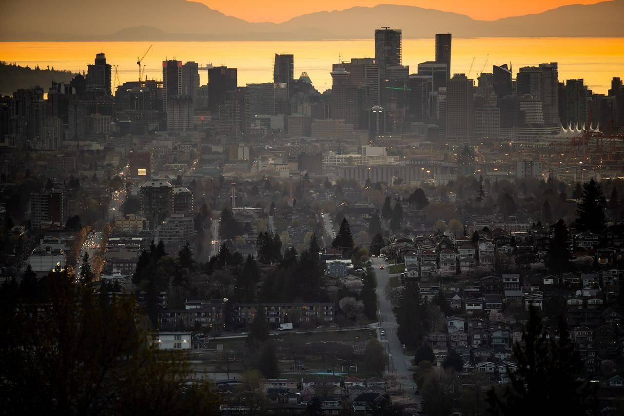 The downtown Vancouver skyline is seen at sunset, as houses line a hillside in Burnaby, B.C., on Saturday, April 17, 2021. Home sales across Metro Vancouver remained well above the 10-year average in September, but the Real Estate Board of Greater Vancouver says prices haven’t climbed as sharply. THE CANADIAN PRESS/Darryl Dyck