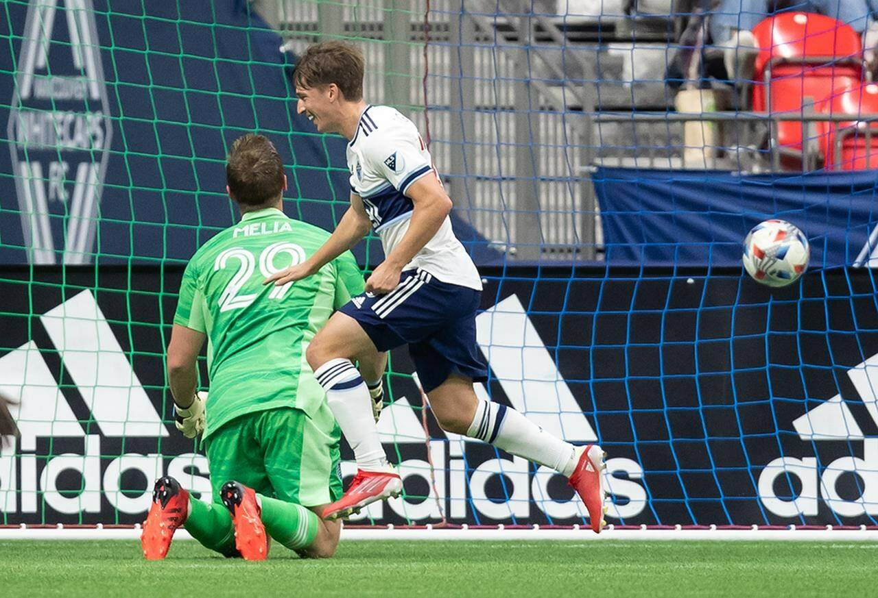 Vancouver Whitecaps’ Ryan Gauld, front, celebrates his goal against Sporting Kansas City goalkeeper Tim Melia during first half MLS soccer action in Vancouver, B.C., Sunday, Oct. 17, 2021. THE CANADIAN PRESS/Darryl Dyck