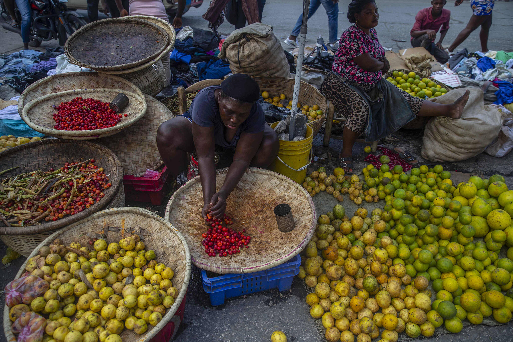 A street vendor prepares her produce for sale in Port-au-Prince, Haiti, Sunday, Oct. 17, 2021. A group of 17 U.S. missionaries including children was kidnapped by a gang in Haiti on Saturday, Oct. 16, according to a voice message sent to various religious missions by an organization with direct knowledge of the incident. (AP Photo / Joseph Odelyn)