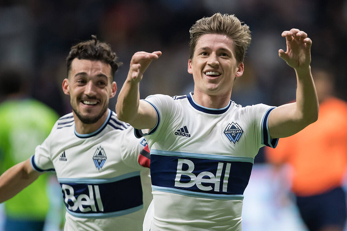 Vancouver Whitecaps’ Ryan Gauld, right, and Russell Teibert celebrate Gauld’s goal against the Seattle Sounders during the first half of an MLS soccer game in Vancouver, B.C., Sunday, Nov. 7, 2021. THE CANADIAN PRESS/Darryl Dyck