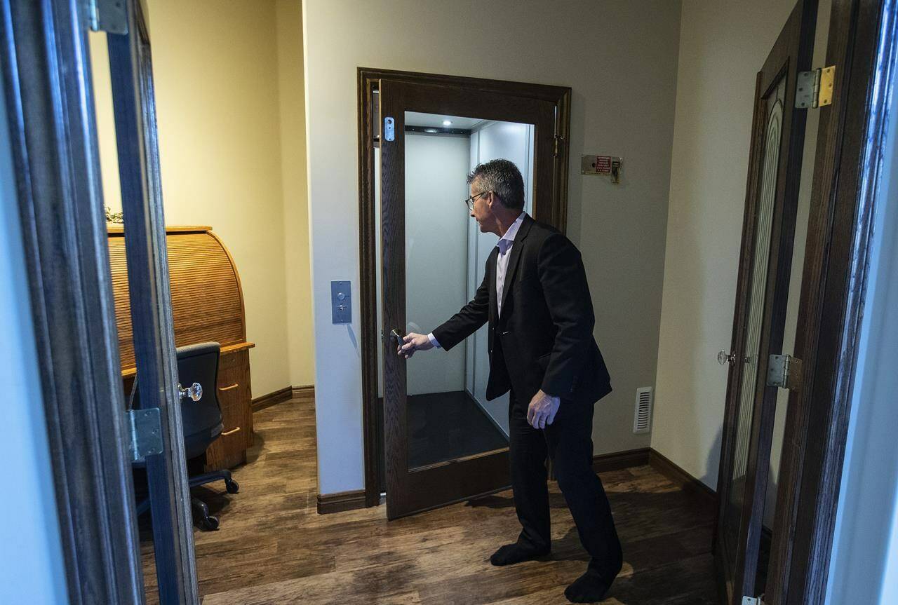 Real estate agent Brian Cyr opens an elevator to the basement of what has been called the gold standard of homes for people with disabilities in St. Albert, Alta., on Thursday, Nov. 4, 2021. THE CANADIAN PRESS/Jason Franson