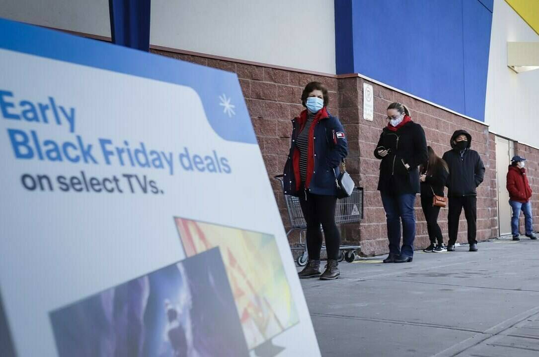 Shoppers wait in line at an electronics store in Calgary, Alta., Friday, Nov. 27, 2020, amid a worldwide COVID-19 pandemic. THE CANADIAN PRESS/Jeff McIntosh