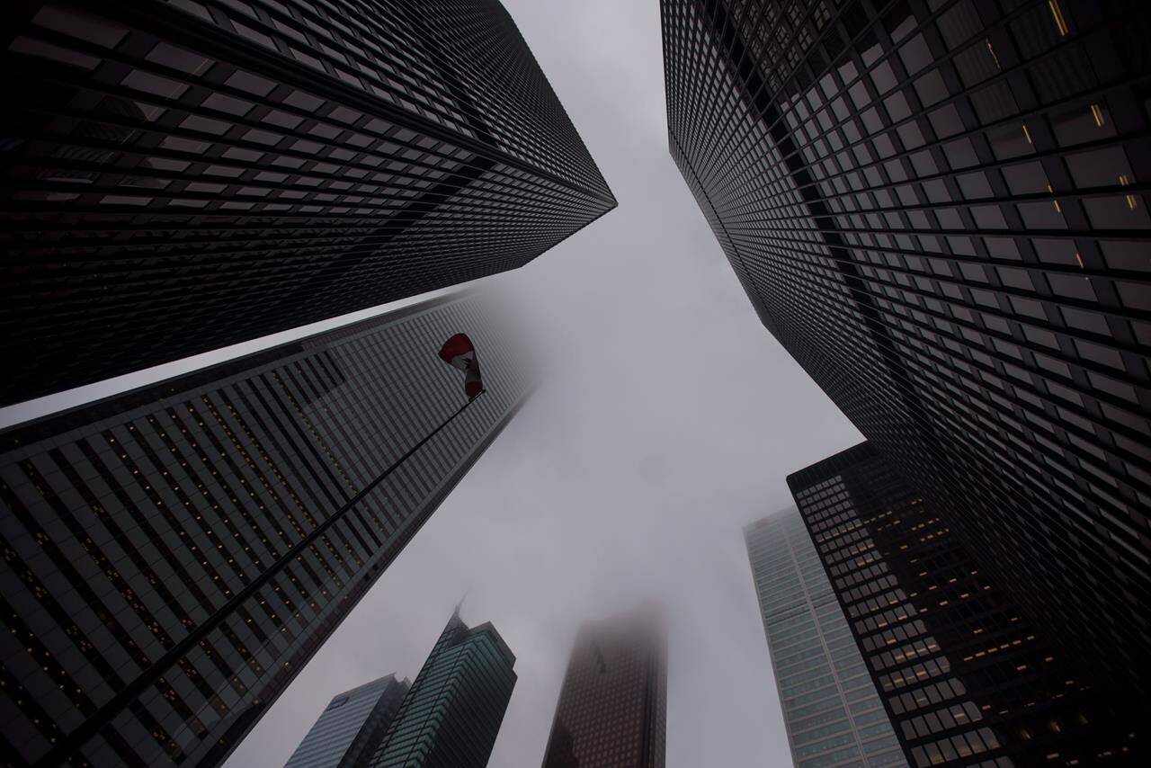 The Canadian flag blows in the wind in the heart of the financial district in Toronto on June 27, 2018. THE CANADIAN PRESS/Tijana Martin