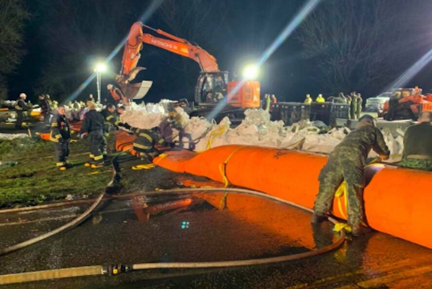 Military personnel help with the placement of a Tiger Dam on Sunday night (Nov. 28) across Highway 1 near Cole Road in Abbotsford. (PHOTO: Abbotsford Police Department)