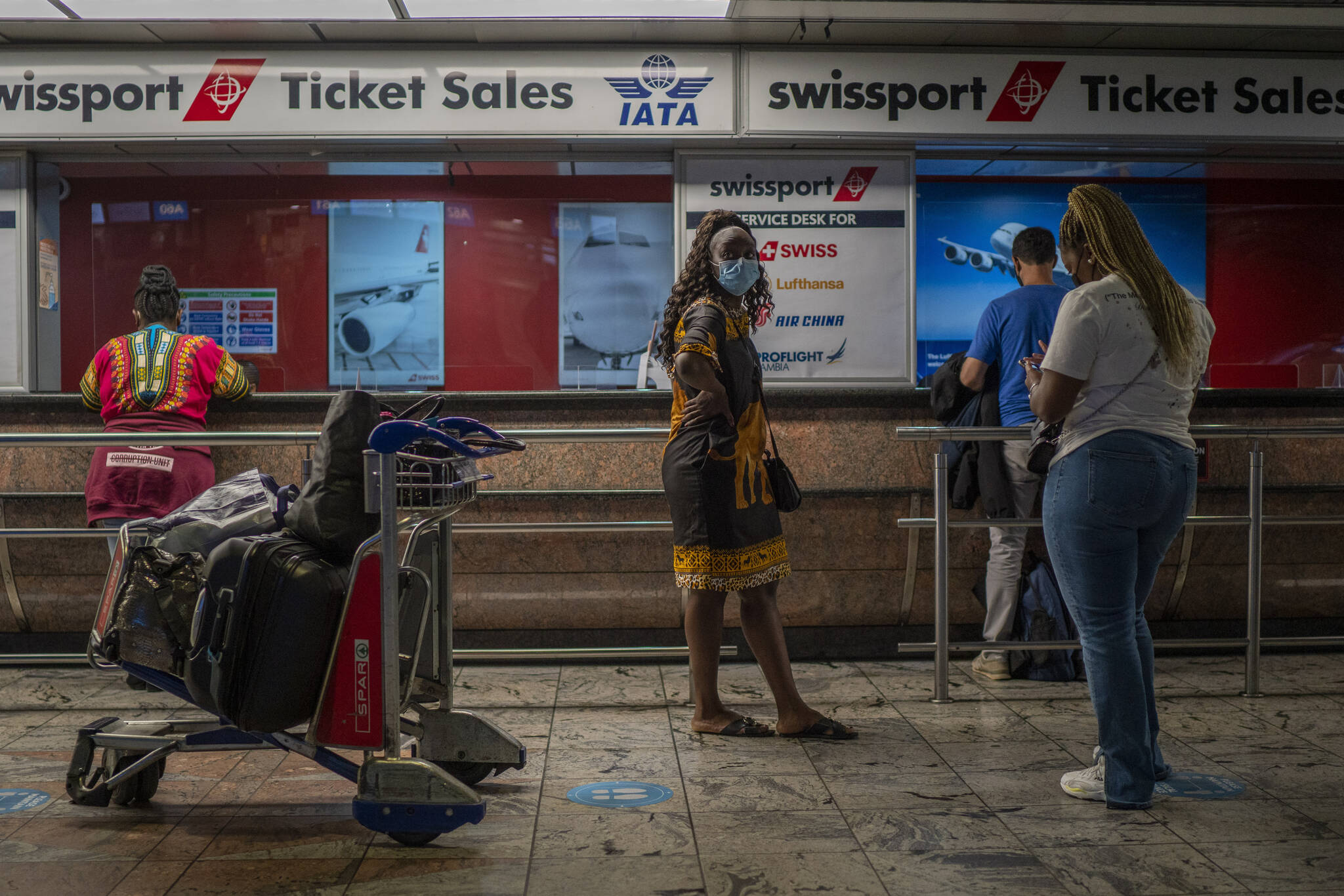 Passengers wait at a ticket counter at Johannesburg’s OR Tambo’s airport, Monday Nov. 29, 2021. The World Health Organisation urged countries around the world not to impose flight bans on southern African nations due to concern over the new omicron variant. (AP Photo/Jerome Delay)