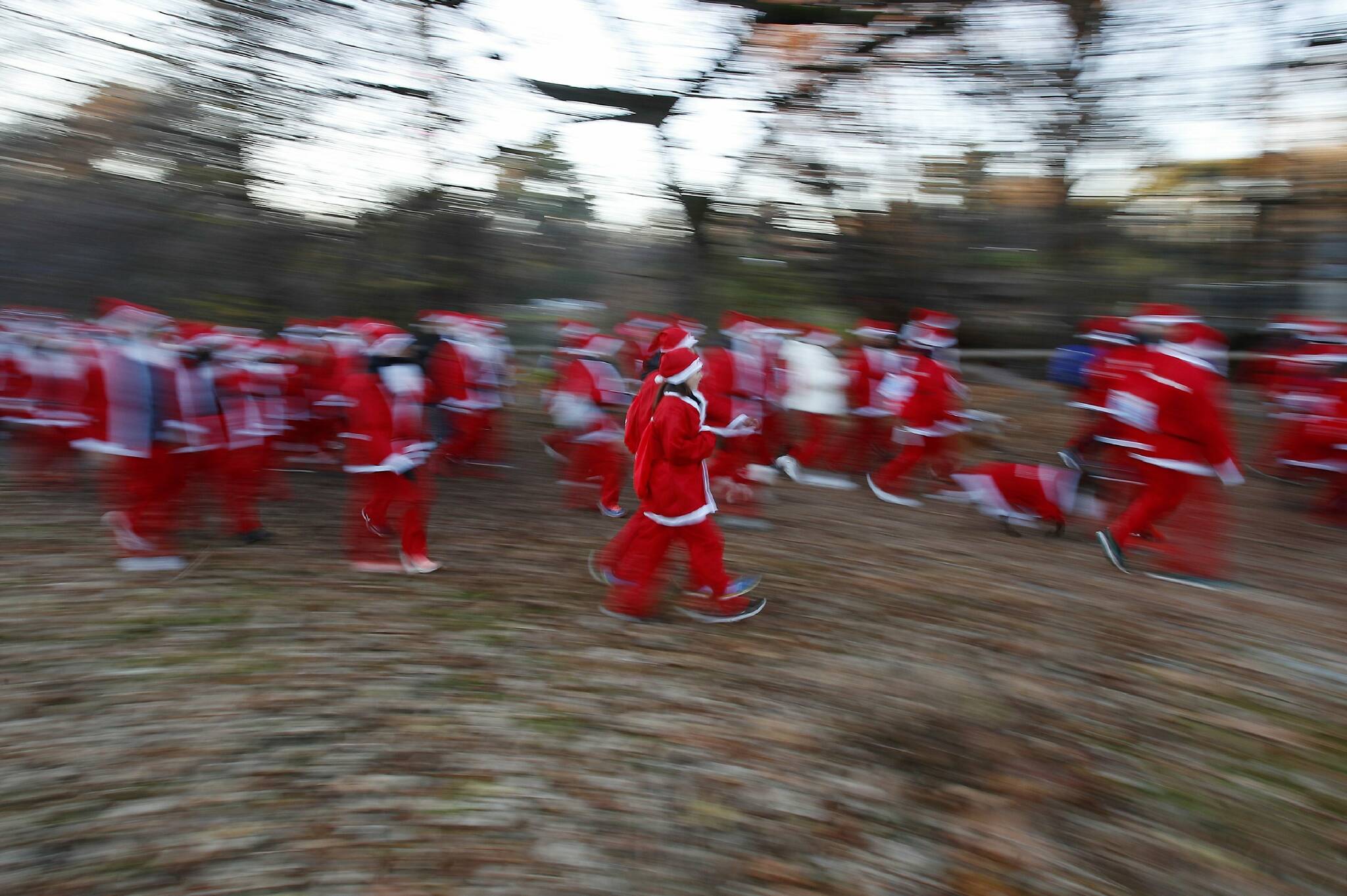 People dressed in Santa Claus costumes take part in Christmas run in Milan, Italy, Saturday, Dec. 14, 2019. (AP Photo/Antonio Calanni)