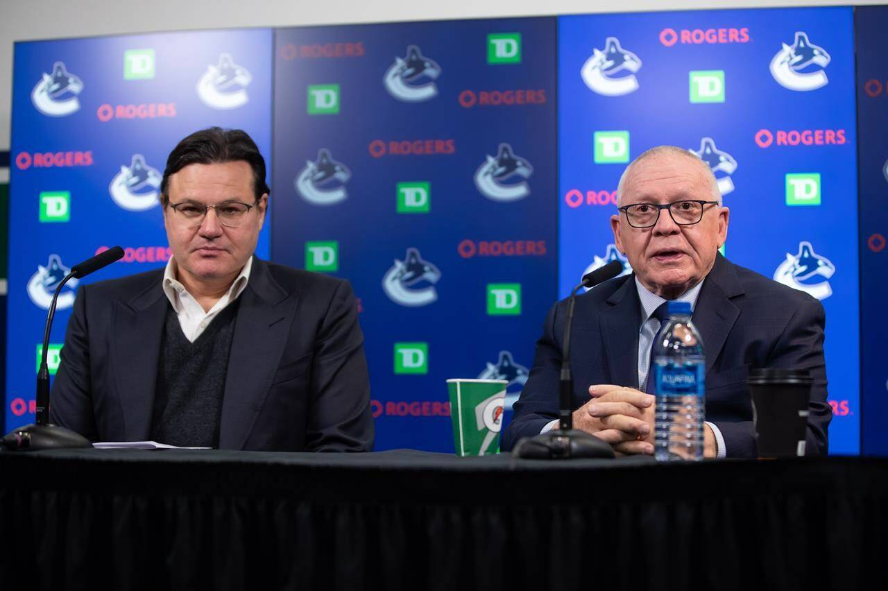 New Vancouver Canucks President of Hockey Operations and Interim General Manager Jim Rutherford, right, responds to questions during his first news conference since being hired by the NHL hockey team, as owner Francesco Aquilini sits with him in Vancouver, on Monday, December 13, 2021. THE CANADIAN PRESS/Darryl Dyck