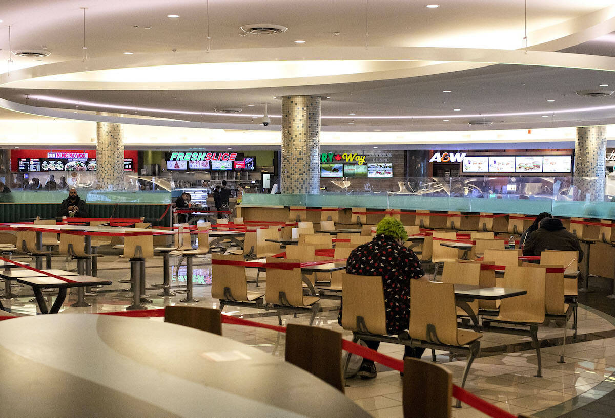 FILE – People eat lunch physically distanced as nearby tables are blocked at a mall food court in Surrey, B.C., Thursday, Dec. 4, 2020. THE CANADIAN PRESS/Marissa Tiel