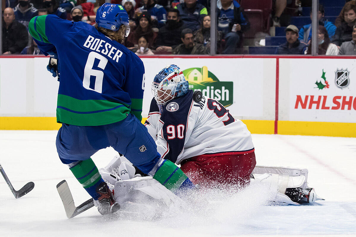Columbus Blue Jackets goalie Elvis Merzlikins (90), of Latvia, stops Vancouver Canucks’ Brock Boeser (6) during the second period of an NHL hockey game in Vancouver, on Tuesday, December 14, 2021. THE CANADIAN PRESS/Darryl Dyck