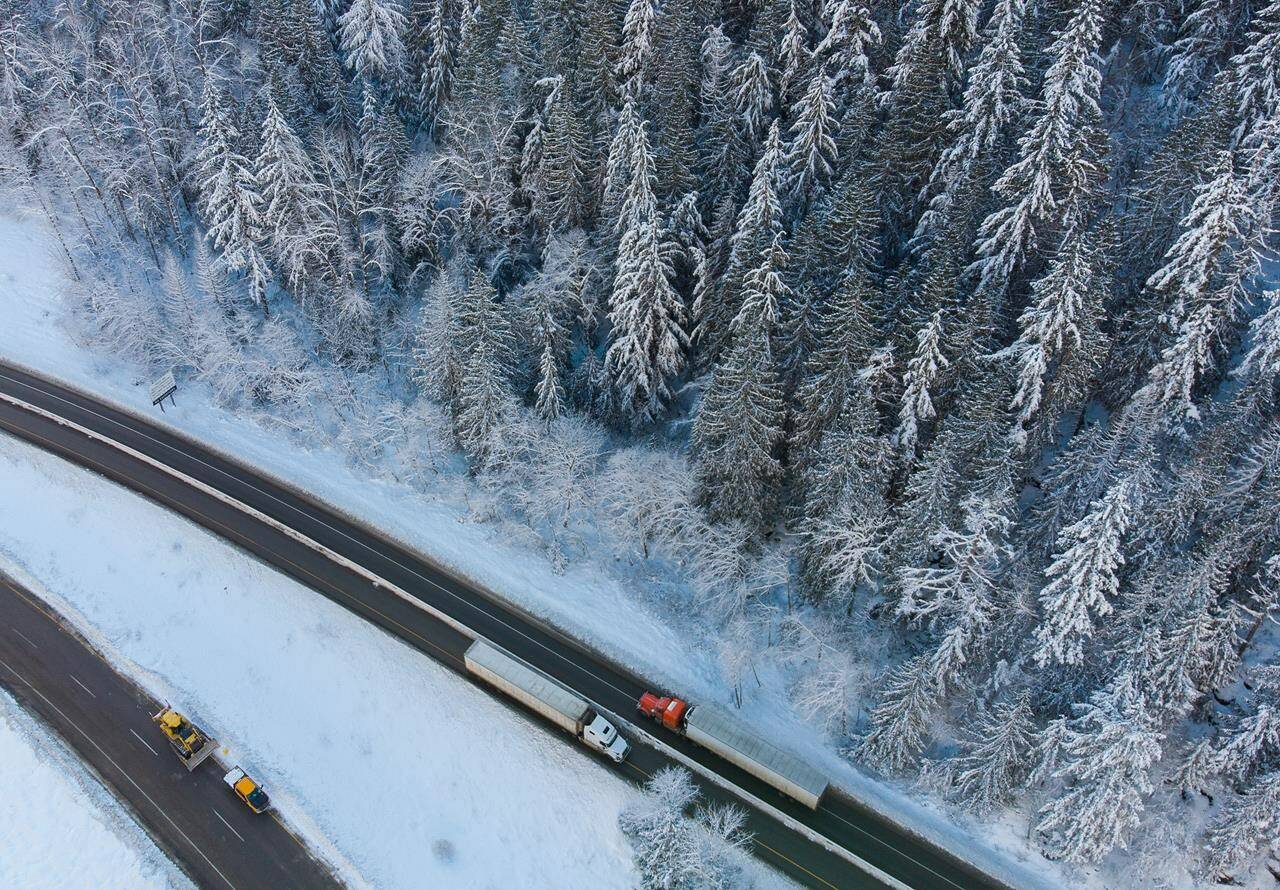 Transport trucks hauling trailers travel on the northbound lanes of the Coquihalla Highway after it was reopened to commercial traffic, at Othello northeast of Hope, B.C., on Monday, December 20, 2021. British Columbia’s “hobbled” supply chains received a major boost with the reopening of the primary transport route for goods heading to and from Metro Vancouver, a spokesman for the trucking industry said. THE CANADIAN PRESS/Darryl Dyck
