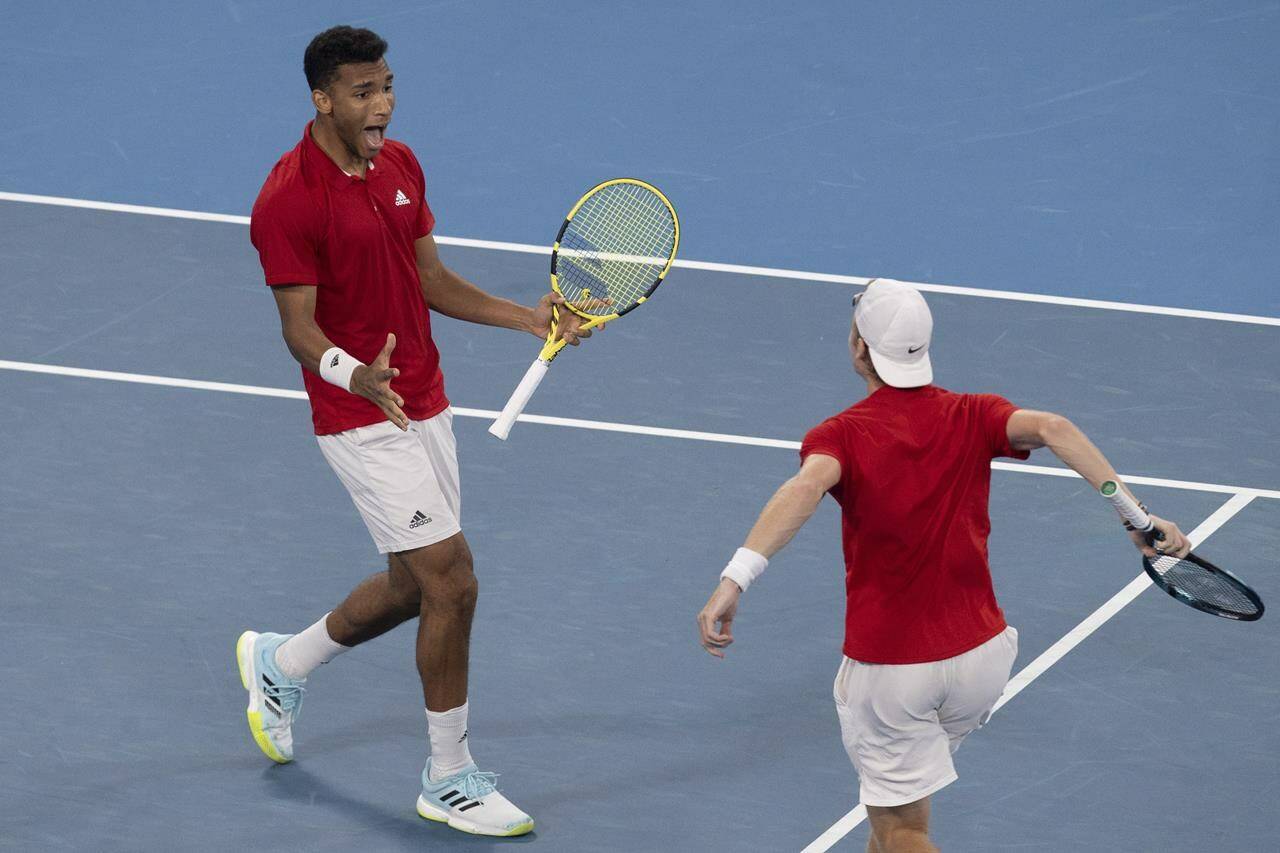 Felix Auger-Aliassime, left, and Denis Shapovalov of Canada react to winning their match against Russia’s Daniil Medvedev and Roman Safiullin during their semifinal match at the ATP Cup tennis tournament in Sydney, Saturday, Jan. 8, 2022. (AP Photo/Steve Christo)