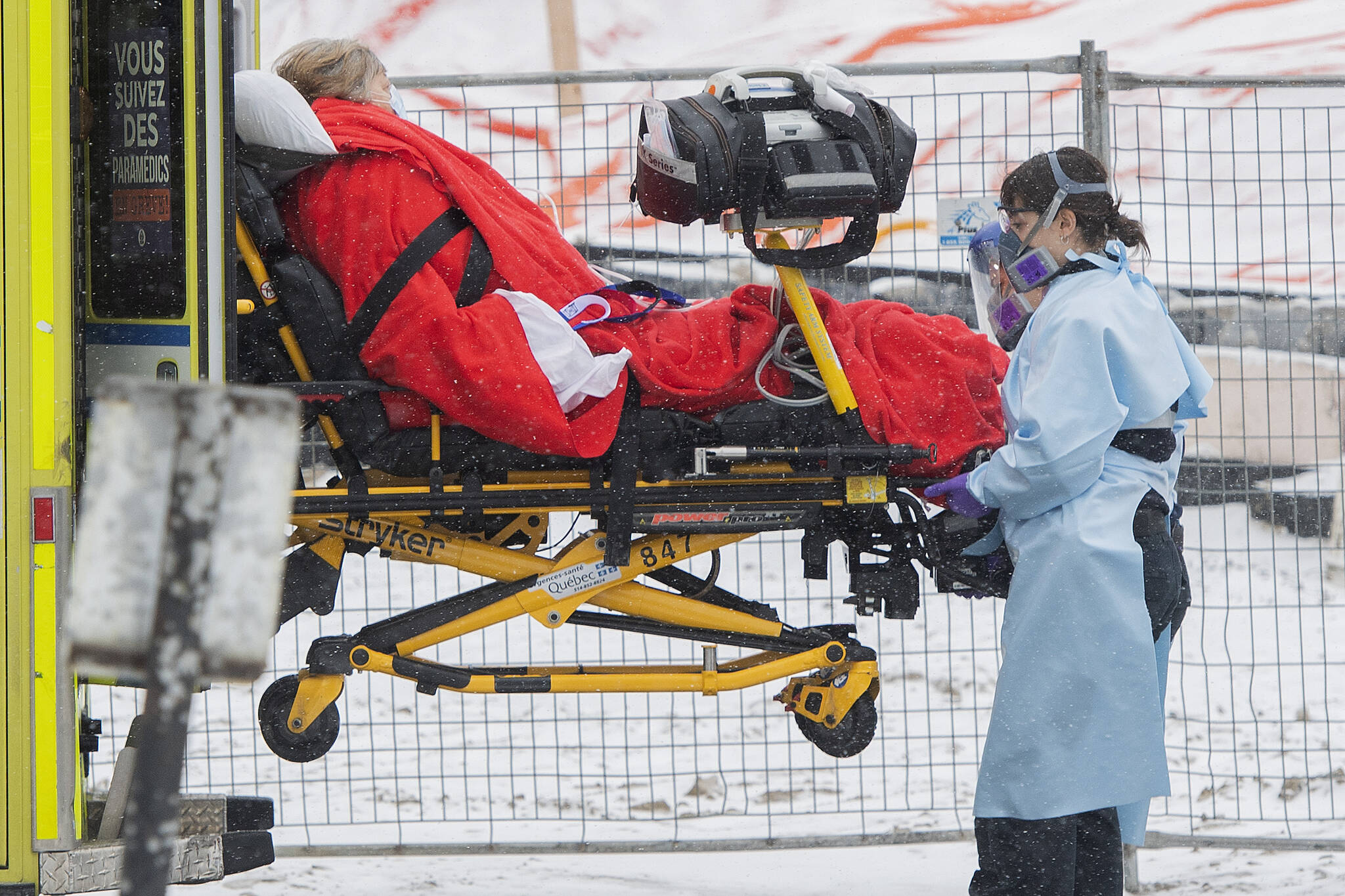 Paramedics transfer a person from an ambulance into a hospital in Montreal, Sunday, Jan. 9, 2022. The Health Department says data from the last 24 hours indicates a 140-jump in hospitalization from the previous day, for a total of 2,436. The province is also reporting 11,007 new cases of COVID-19. THE CANADIAN PRESS/Graham Hughes