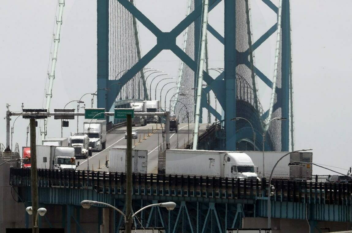In this Tuesday, June 12, 2018, photo, trucks cross the Ambassador Bridge from Windsor, Ont. into Detroit. Turmoil and confusion last week over whether truckers would remain exempt from the COVID-19 vaccine mandate followed misinterpretations of regulations by both the Public Health Agency of Canada and the Canada Border Services Agency. THE CANADIAN PRESS/AP, Paul Sancya