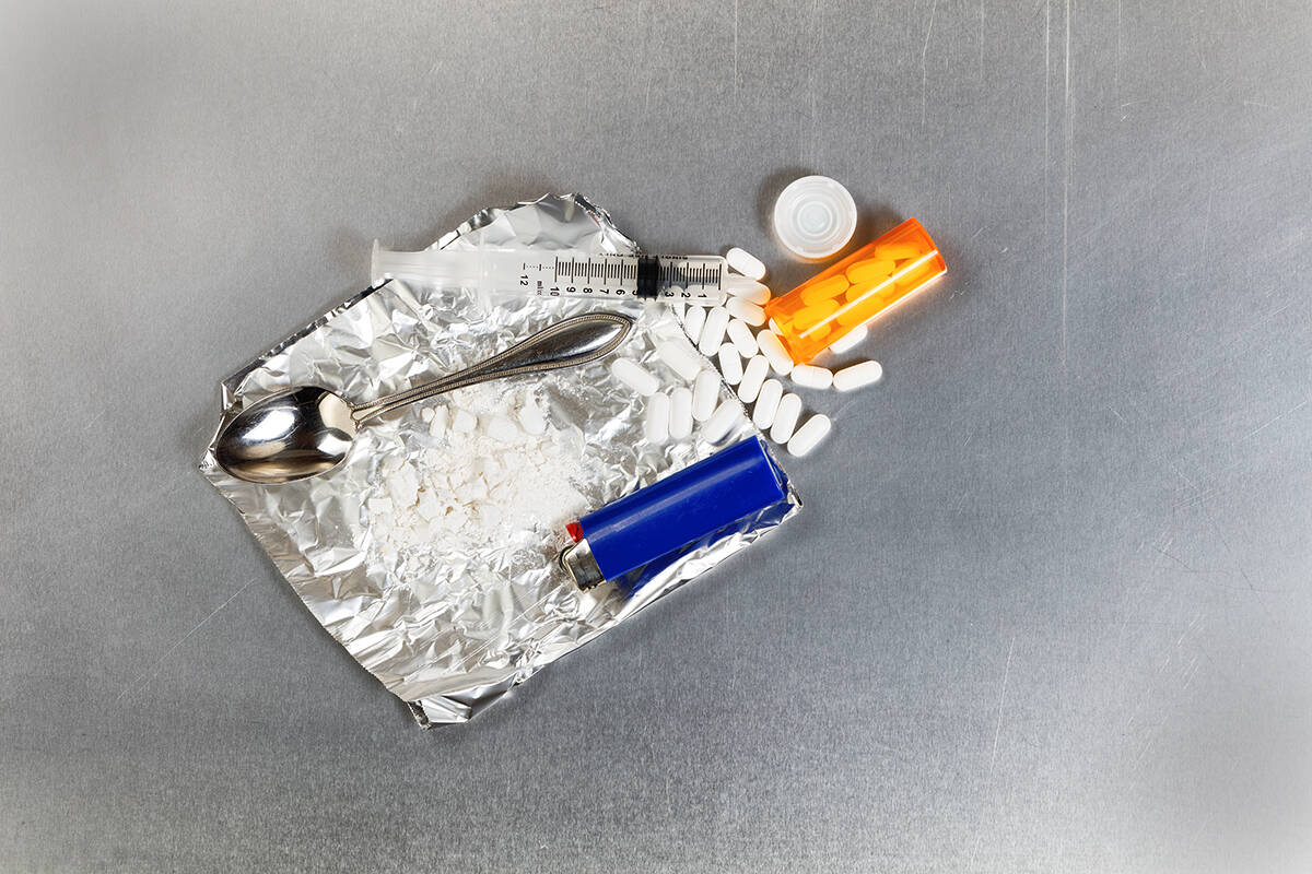 Tools of the trade: Crushed painkiller pills with open bottle, aluminum foil, spoon, lighter and syringe. ADOBE STOCK IMAGE