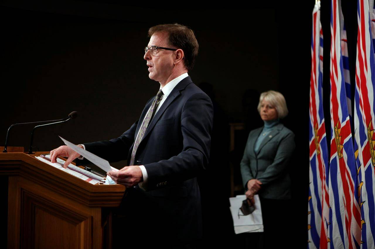 Provincial Health Officer Dr. Bonnie Henry looks on as Health Minister Adrian Dix speaks during a COVID-19 update press conference in Victoria, Tuesday, Dec. 21, 2021. Guidance on the home management of COVID-19 symptoms and decisions about who should self-isolate and for how long could dominate the Friday pandemic update with British Columbia’s health minister and top doctor. THE CANADIAN PRESS/Chad Hipolito