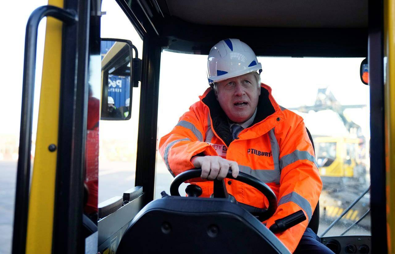 British Prime Minister Boris Johnson drives a forklift as he visits the Tilbury Docks in Tilbury, England, Monday, Jan. 31, 2022. The port, located on the River Thames, handles a variety of bulk cargo and container traffic is one of Britain’s three major container ports. (AP Photo/Matt Dunham, Pool)