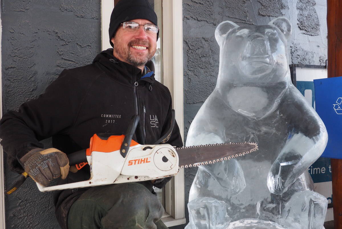 Fernie local Dave Richards with his latest carving creation - an ice bear carved from ice from Crowsnest Pass Lake. (Scott Tibballs / The Free Press)