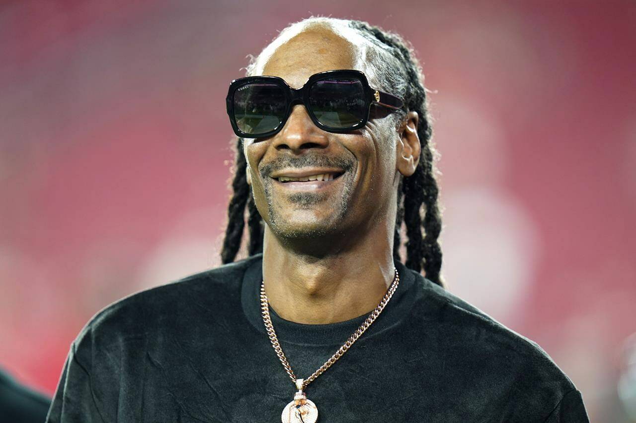 FILE - Entertainer Snoop Dogg walks on the field before an NFL football game between the Tampa Bay Buccaneers and the New Orleans Saints Sunday, Dec. 19, 2021, in Tampa, Fla. Snoop Dogg says he won’t let the big Super Bowl stage rattle his nerves. The ultra-smooth rapper said he will worry about his upcoming halftime performance after the fact. He’ll take the stage with Dr. Dre, Eminem, Kendrick Lamar and Mary J. Blige during Super Bowl 56 on Sunday, Feb. 13, 2022. (AP Photo/Chris O’Meara, File)
