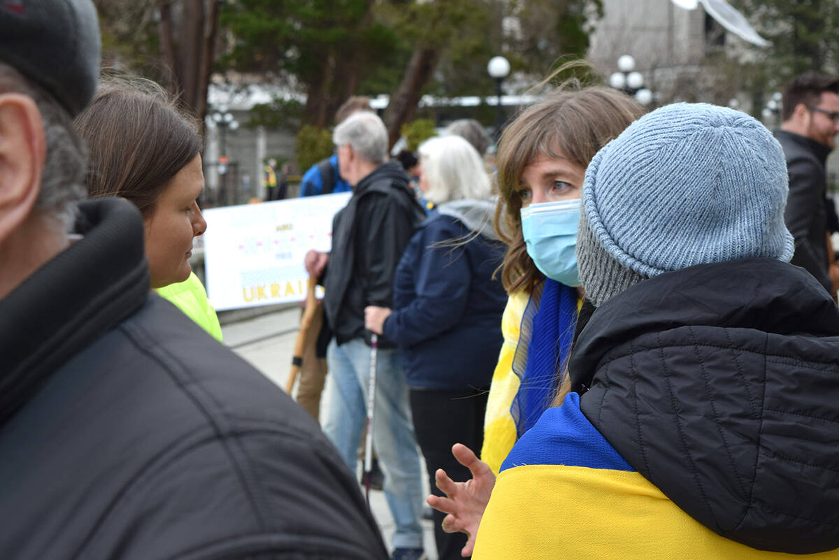 NDP MP of Victoria Laurel Collins (center) could be seen speaking with Ukrainian residents of Victoria about having their families relocated to Canada, during Feb. 27, 2022’s rally for Ukraine at the B.C. Legislature. (Kiernan Green/News Staff)