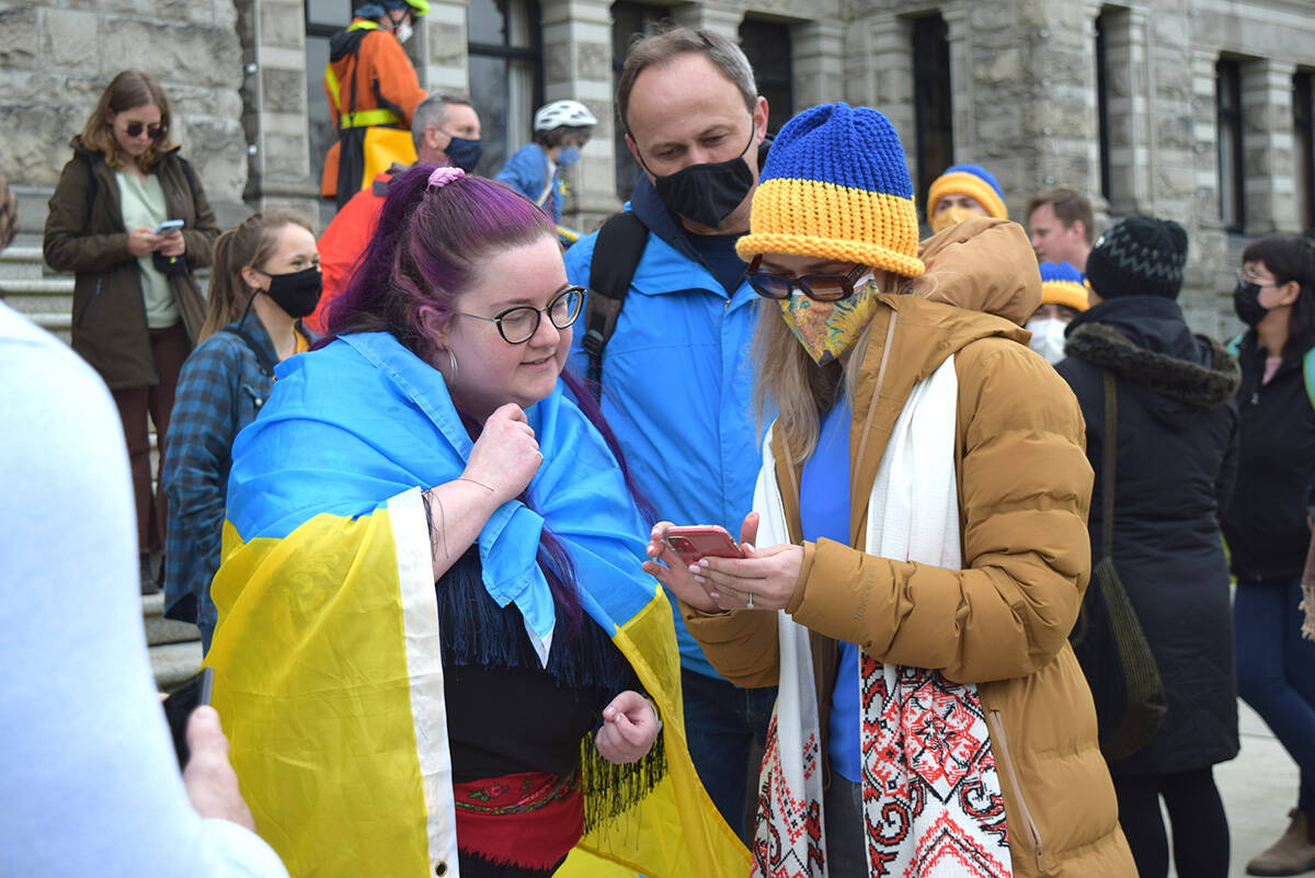 Devon Sereda Goldie, president of Victoria’s Ukrainian Cultural Centre (right), instructs on what to mail MP’s in support of Ukraine during Feb. 27, 2022’s rally at the B.C. Legislature. (Kiernan Green/News Staff)