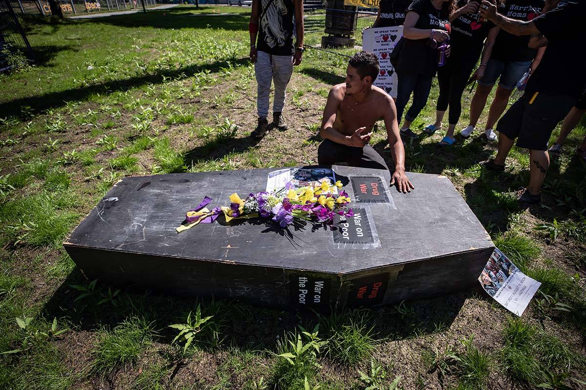A man pauses at a coffin after carrying it during a memorial march to remember victims of overdose deaths in Vancouver on August 15, 2020. Advocates say Health Canada’s announcement to decriminalize personal possession of 2.5 grams will do little to save people’s lives. THE CANADIAN PRESS/Darryl Dyck