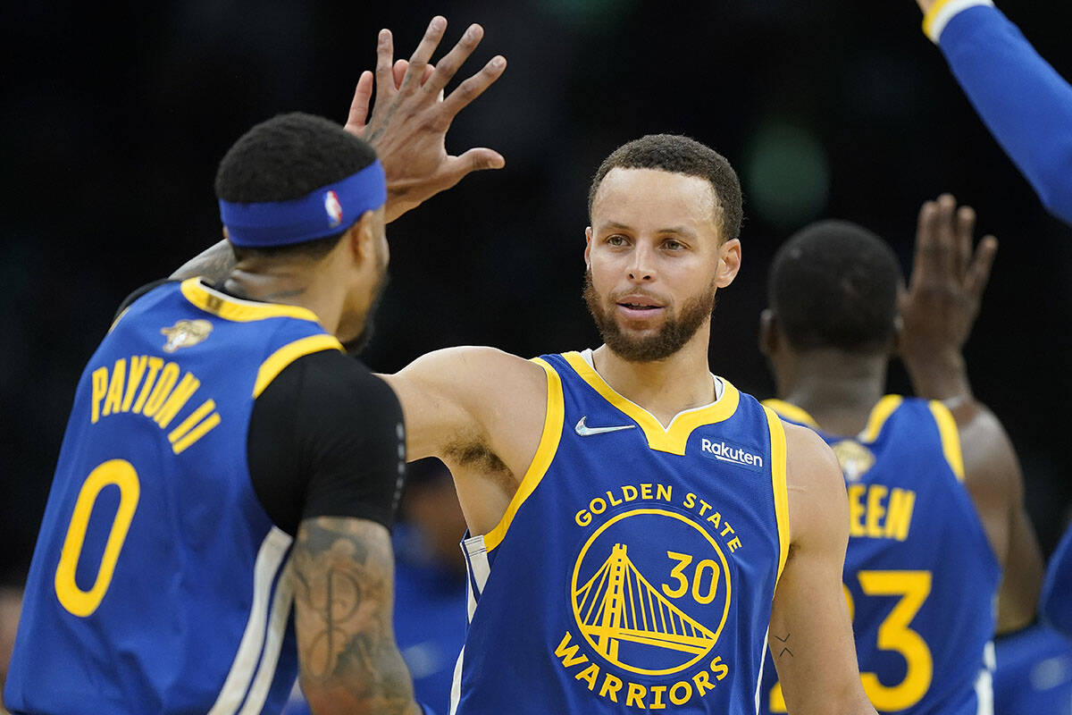 Golden State Warriors guard Stephen Curry (30) high fives Golden State Warriors guard Gary Payton II (0) during the second quarter of Game 6 of basketball’s NBA Finals against the Boston Celtics, Thursday, June 16, 2022, in Boston. (AP Photo/Steven Senne)
