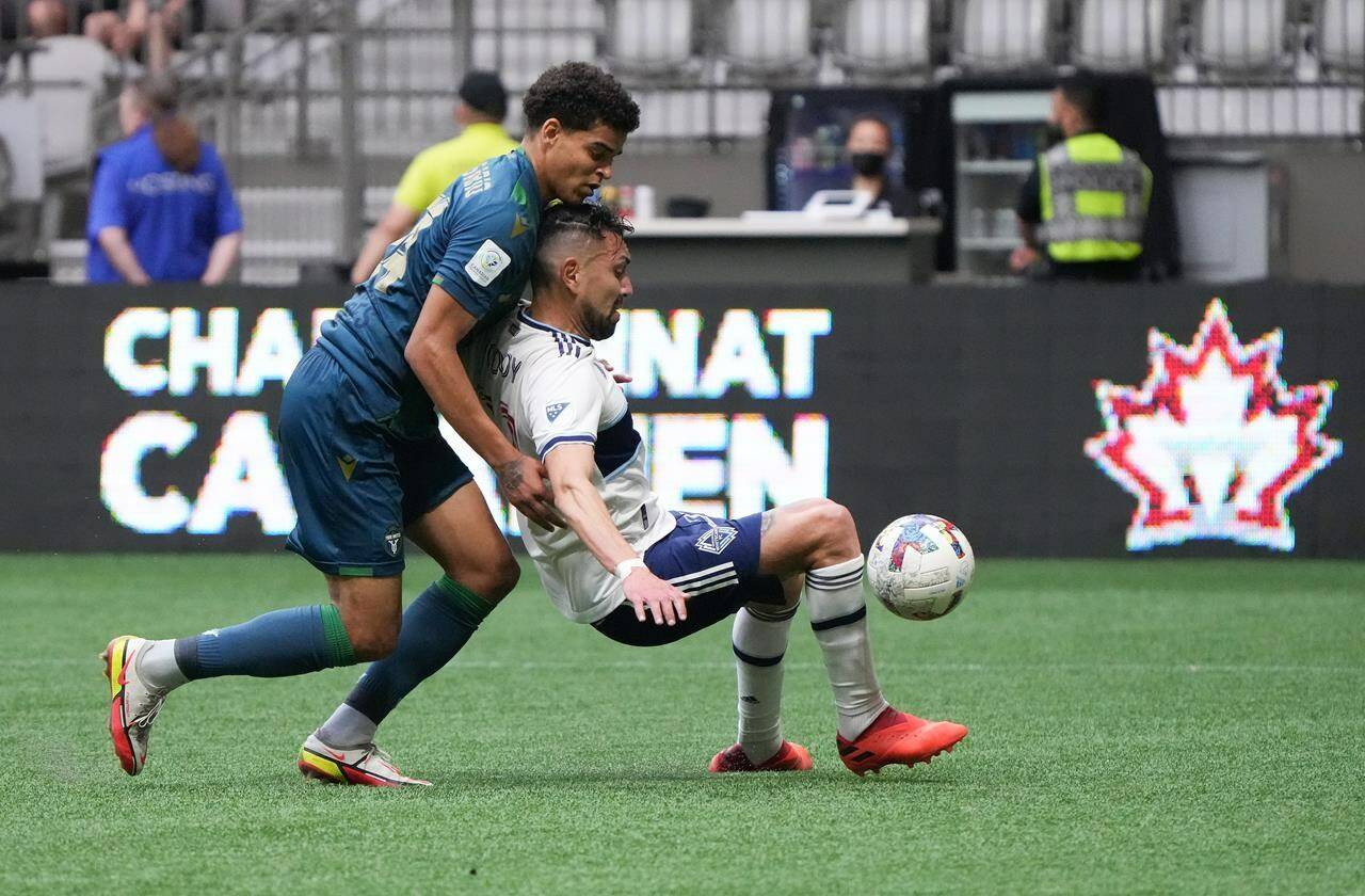 York United’s Osaze De Rosario, left, and Vancouver Whitecaps’ Erik Godoy vie for the ball during the first half of a Canadian Championship semifinal soccer match, in Vancouver, on Wednesday, June 22, 2022. THE CANADIAN PRESS/Darryl Dyck