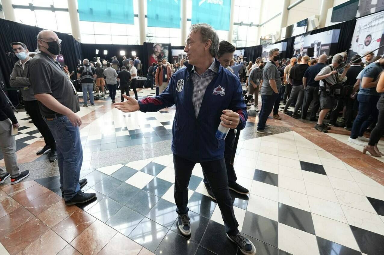 Colorado Avalanche general manager Joe Sakic, center, talks with reporters during media day before Game 1 of the Stanley Cup Finals against the Tampa Bay Lightning, Tuesday, June 14, 2022, in Denver. (AP Photo/David Zalubowski)