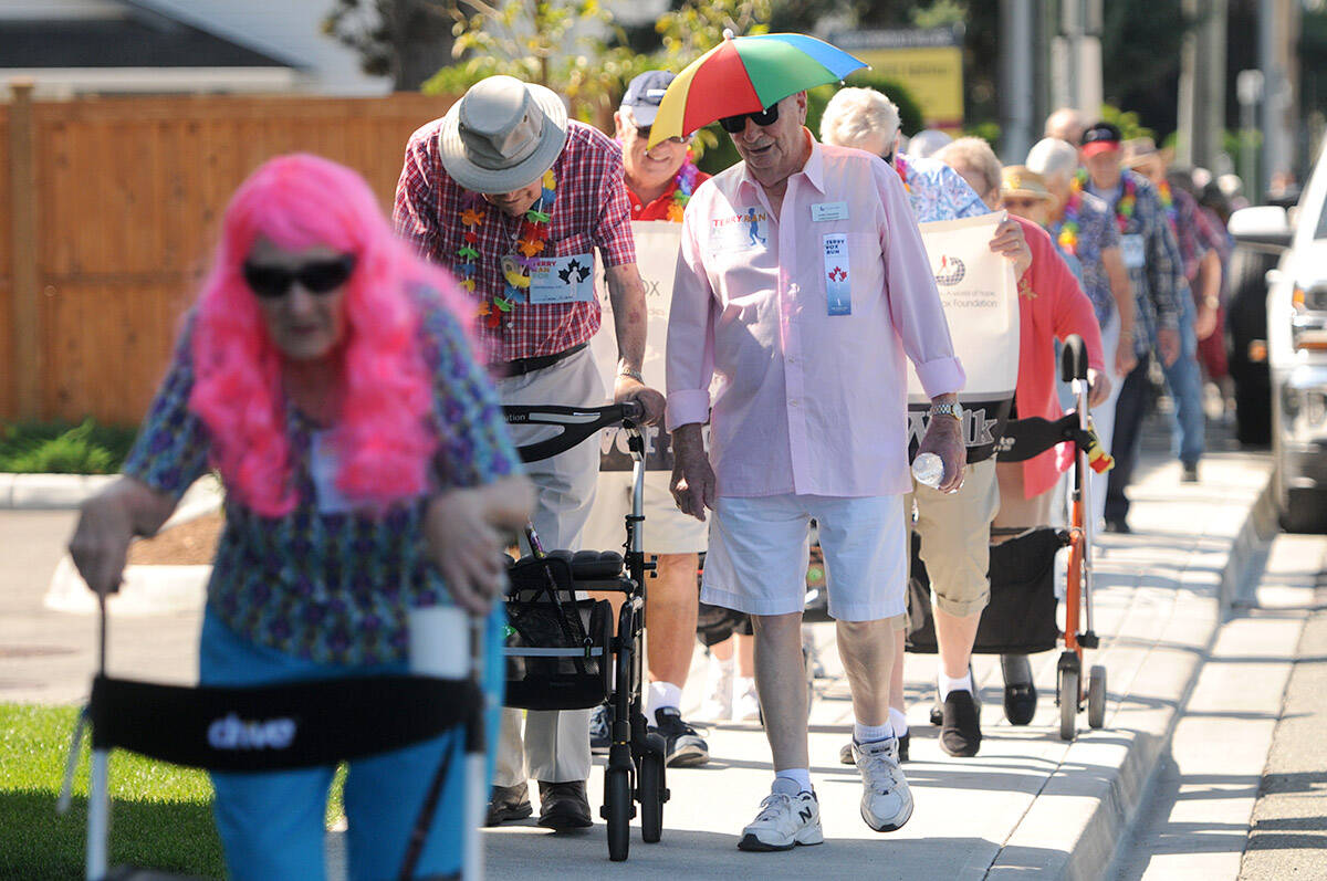 Vern Drader wears an umbrella hat while taking part in the one-kilometre Silver Fox Block Walk, a fundraiser for the Terry Fox Foundation in Chilliwack on Aug. 28, 2019. Wednesday, July 6, 2022 is Umbrella Cover Day. (Jenna Hauck/ Chilliwack Progress file)
