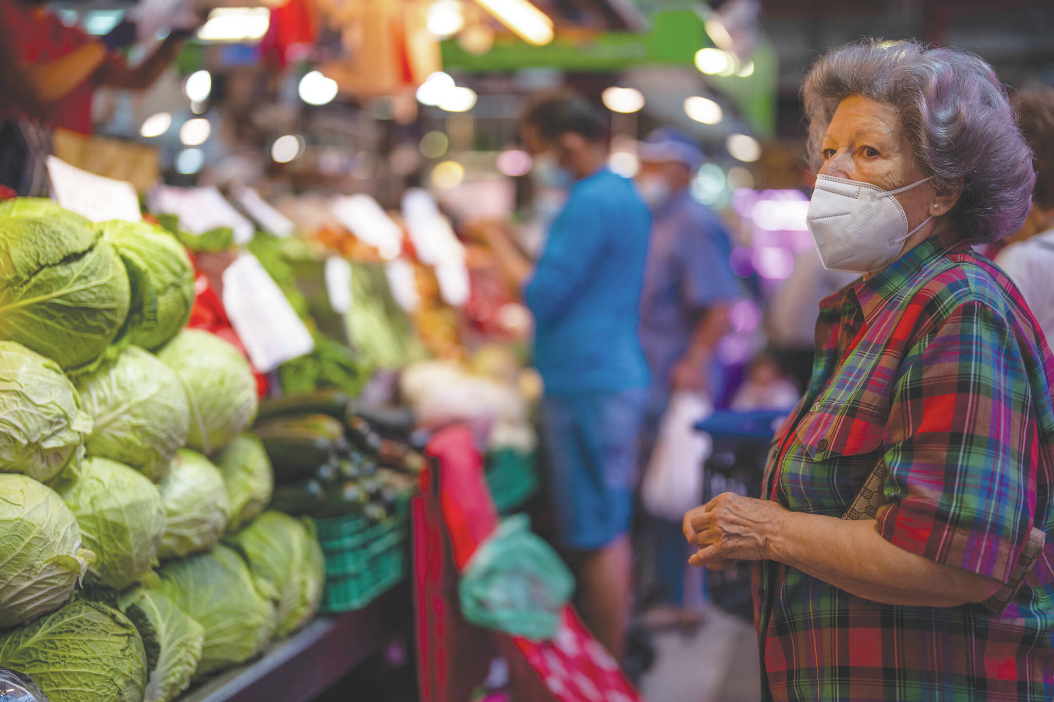 A customer wearing a face mask waits to buy vegetables. (AP Photo/Manu Fernandez)