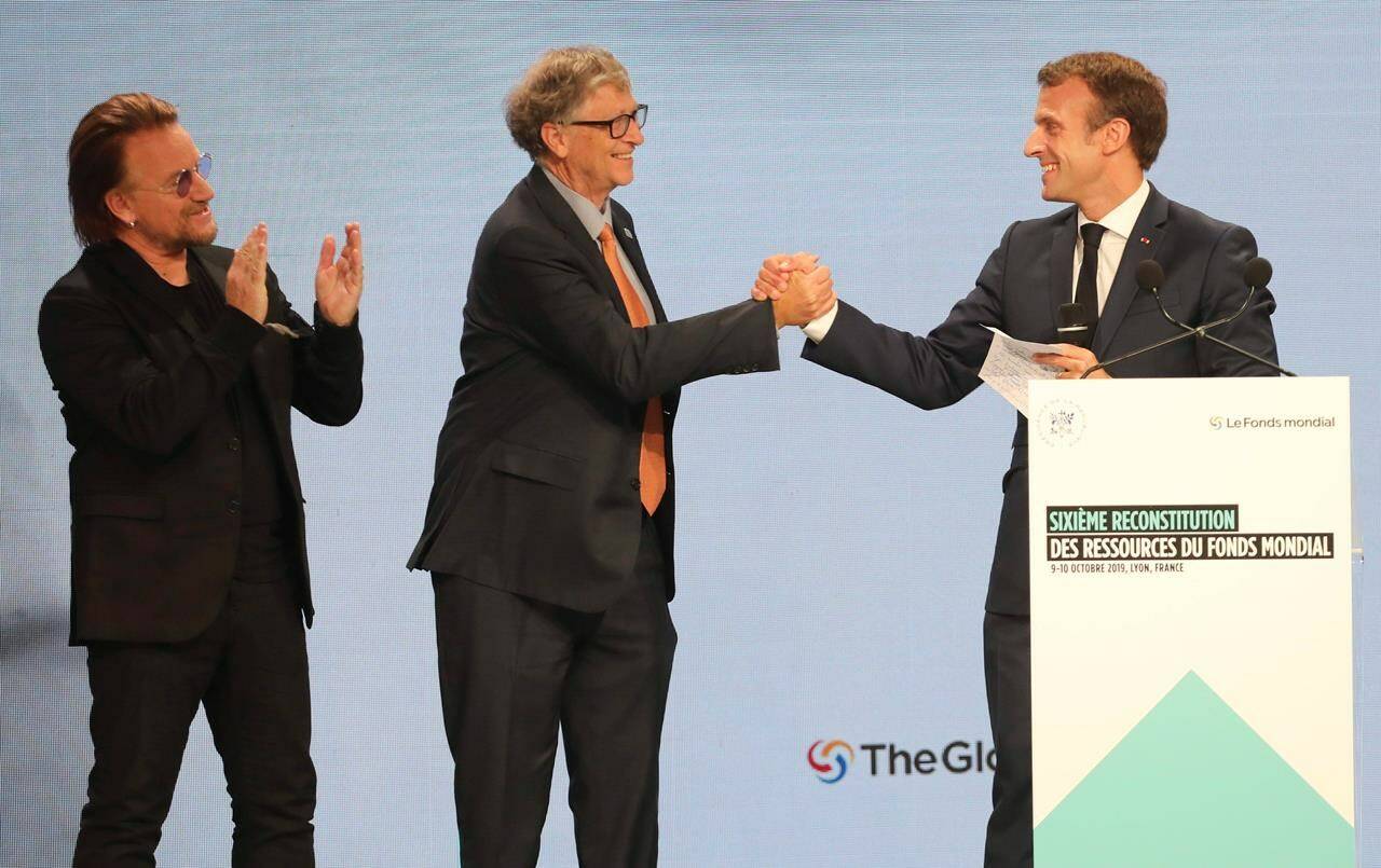 From left to right, U2 singer Bono, Philanthropist and Co-Chairman of the Bill and Melinda Gates Foundation, Bill Gates, and France’s President Emmanuel Macron congratulate each other on stage during the Global Fund to Fight AIDS event at the Lyon’s congress hall, central France, Thursday, Oct. 10, 2019. THE CANADIAN PRESS/AP-Laurent Cipriani