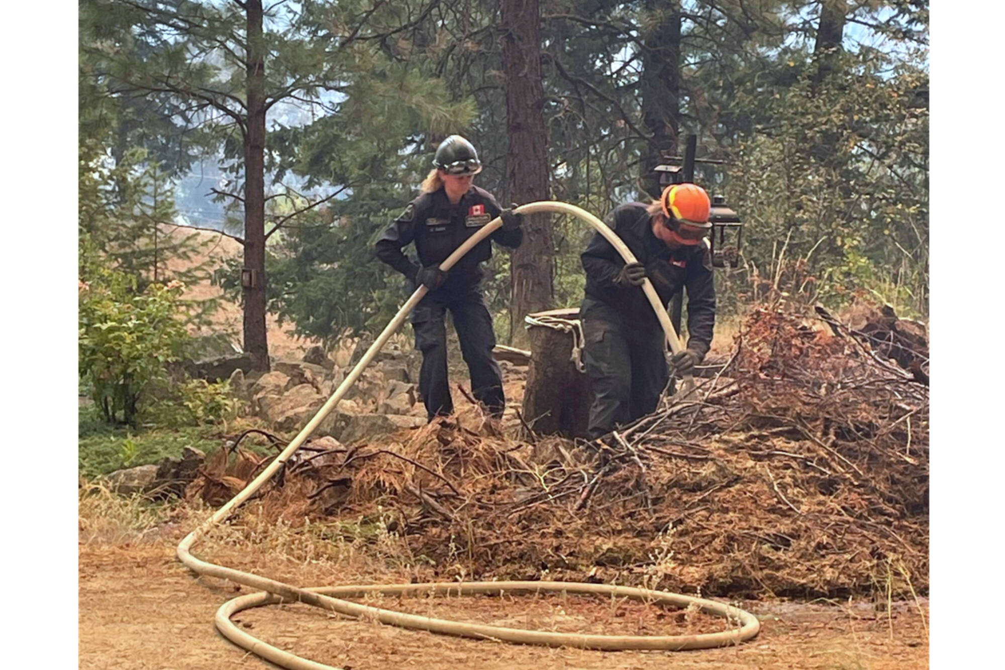Team Leader Kara Slous, left, and Firefighter Matthew Denny work on fire suppression activities for the Keremeos Creek Fire southwest of Penticton. (CSRD photo)