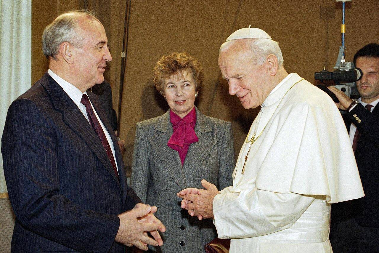 FILE - Pope John Paul II talks to Soviet President Mikhail Gorbachev, as Raisa looks on, during a private visit to the Vatican City, Sunday, Nov. 18, 1990. When Mikhail Gorbachev is buried Saturday at Moscow’s Novodevichy Cemetery, he will once again be next to his wife, Raisa, with whom he shared the world stage in a visibly close and loving marriage that was unprecedented for a Soviet leader. Gorbachev’s very public devotion to his family broke the stuffy mold of previous Soviet leaders, just as his openness to political reform did. (AP Photo/Gianni Foggia, File)
