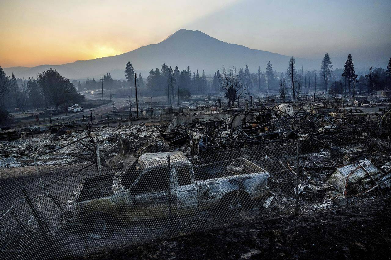 The sun rises over Mt. Shasta and homes destroyed by the Mill Fire on Saturday, Sept. 3, 2022, in Weed, Calif. THE CANADIAN PRESS/AP-Noah Berger