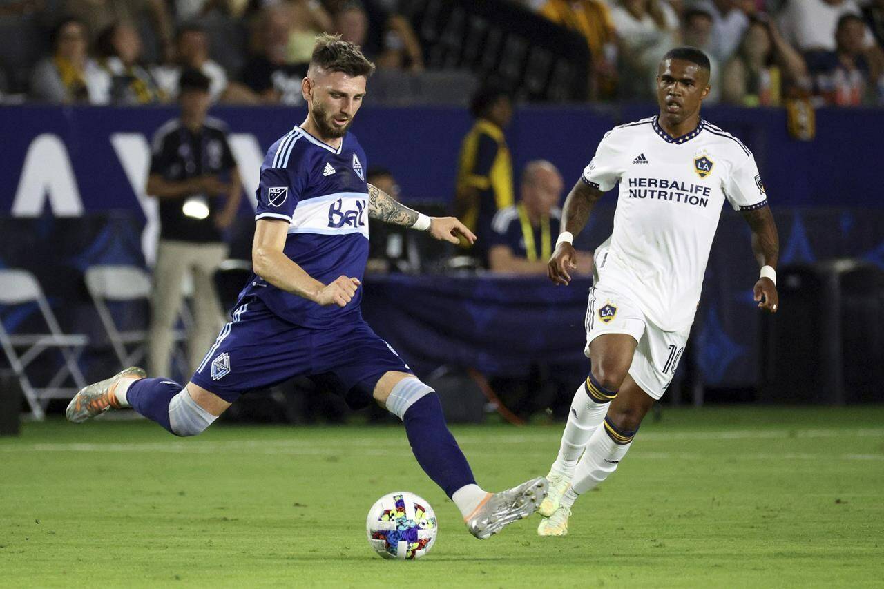 Vancouver Whitecaps defender Tristan Blackmon, left, moves the ball past LA Galaxy forward Douglas Costa during the second half of an MLS soccer match in Carson, Calif., Saturday, Aug. 13, 2022. With just four games left on the schedule, the ‘Caps (9-14-7) are on a three-game losing skid and their playoff hopes have all but evaporated. THE CANADIAN PRESS/AP-Raul Romero Jr.