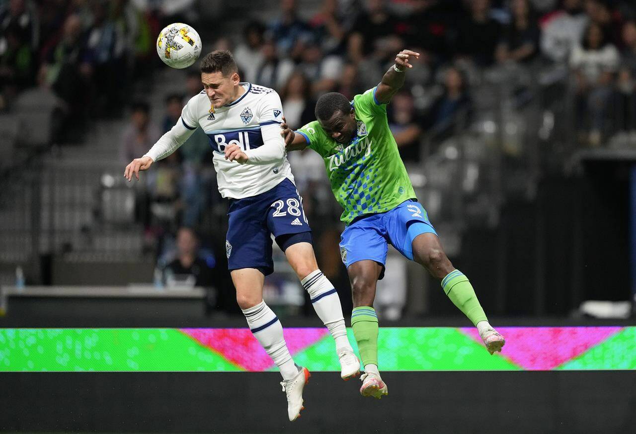 Vancouver Whitecaps’ Jake Nerwinski, left, gets his head on a pass intended for Seattle Sounders’ Nouhou Tolo during the first half of an MLS soccer game in Vancouver, on Saturday, September 17, 2022. THE CANADIAN PRESS/Darryl Dyck