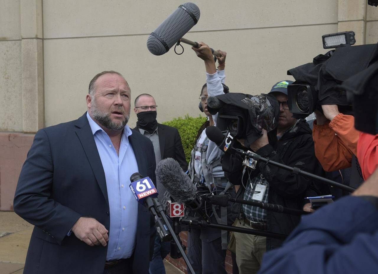 Alex Jones speaks with the media outside of Superior Court in Waterbury, Conn., on Thursday, Sept. 22, 2022. Jones is going to take the stand to testify in a trial in Connecticut over how much in damages he must pay for calling the Sandy Hook school shooting a hoax. (H John Voorhees III /Hearst Connecticut Media via AP)