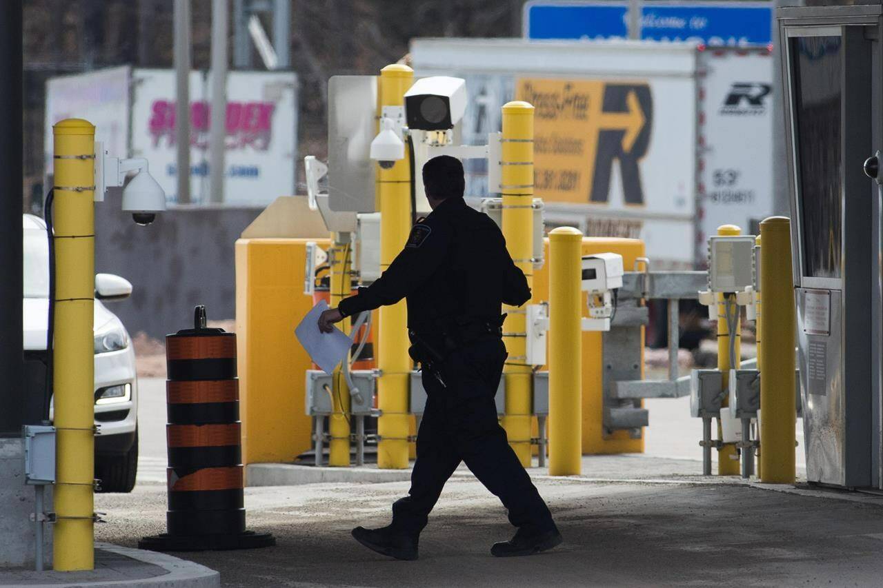 A border officer walks past security cameras at the Thousand Islands border, near Gananqoue, Ont., Monday, March 16, 2020. The federal privacy watchdog says a data breach at a contractor for Canada’s border agency involved as many as 1.38 million licence plate images. THE CANADIAN PRESS/Lars Hagberg