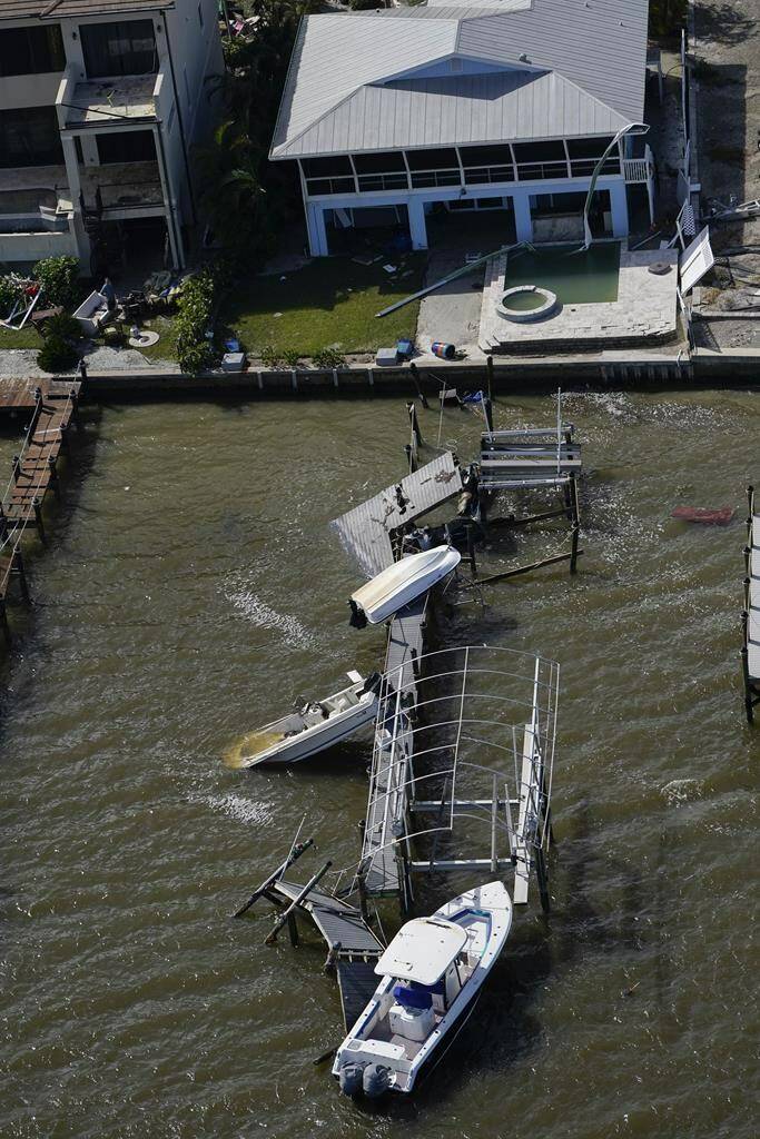 Boats and a damaged home are seen in the aftermath of Hurricane Ian, Thursday, Sept. 29, 2022, in Fort Myers Beach, Fla. (AP Photo/Wilfredo Lee)