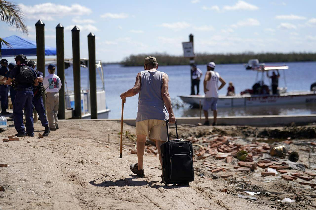 Residents who rode out the storm arrive at a dock to evacuate by boat in the aftermath of Hurricane Ian, on Pine Island in Florida’s Lee County, Sunday, Oct. 2, 2022. The only bridge to the island is heavily damaged so it can only be reached by boat or air. (AP Photo/Gerald Herbert)